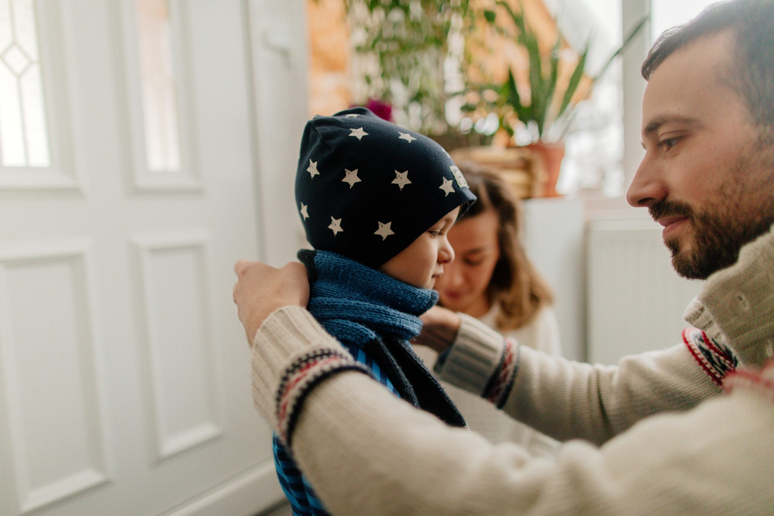 Photo of a young family putting some warm clothes on and getting ready for winter activities